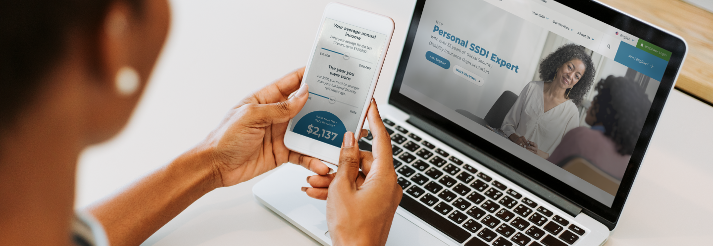 Person Looking at Phone Screen in Front of Another Laptop Screen